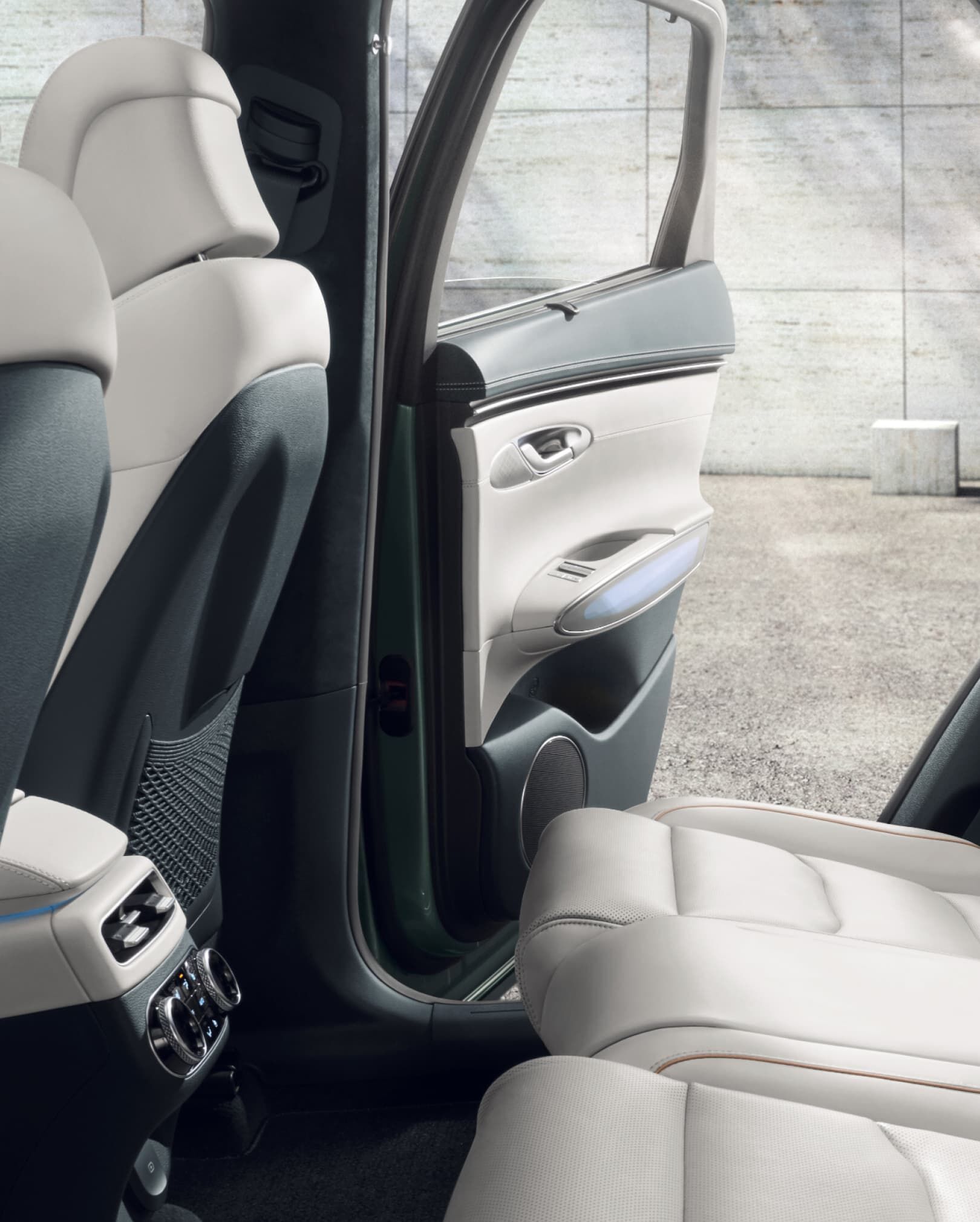 The Ocean Wave Blue & Glacier White 2nd-row space looks comfortable. The right back door is open. 