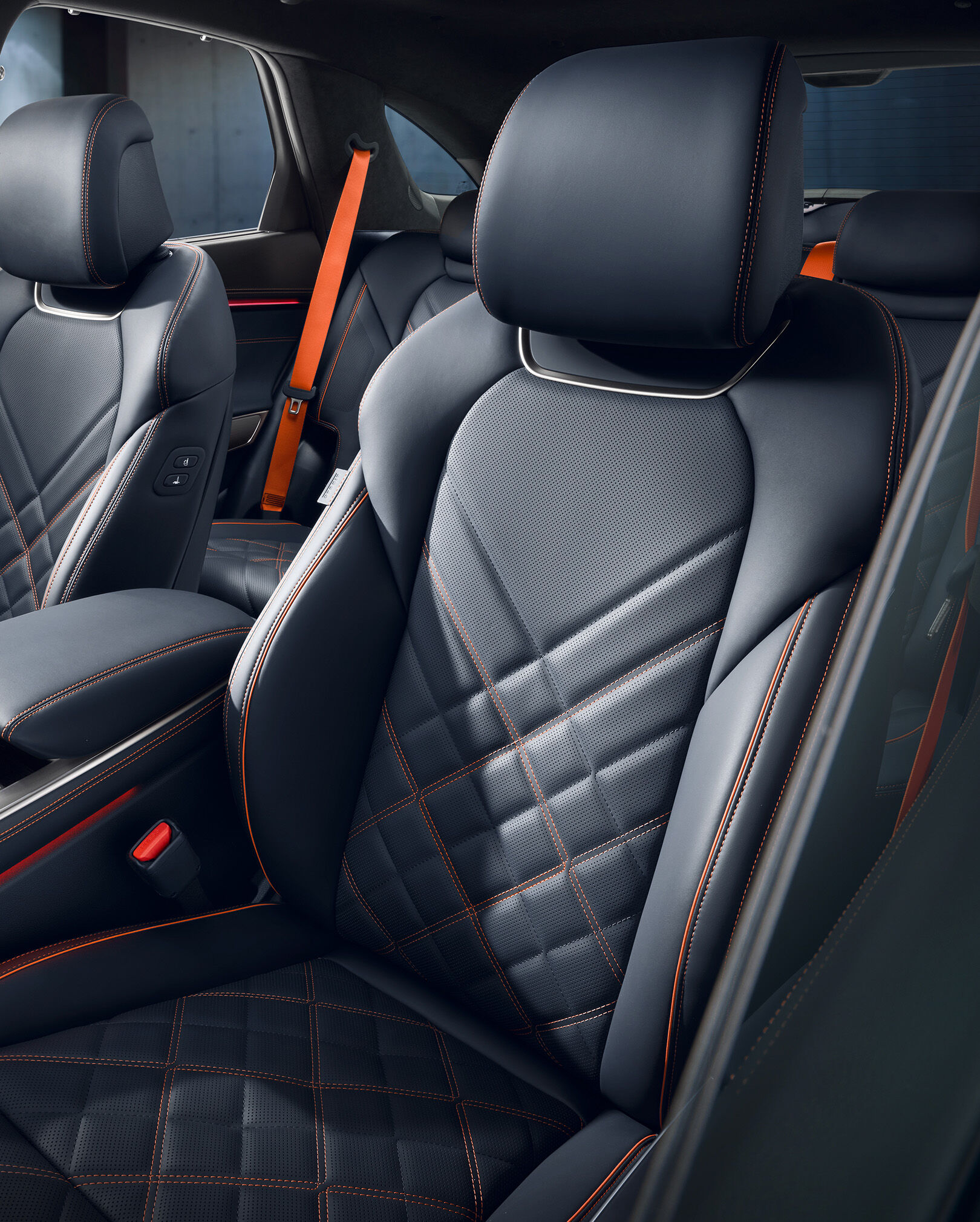 The orange stitching and black leather-designed seats of the  GV70 Sports Package are highlighted.