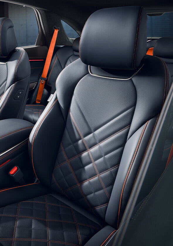 The orange stitching and black leather-designed seats of the  GV70 Sports Package are highlighted.